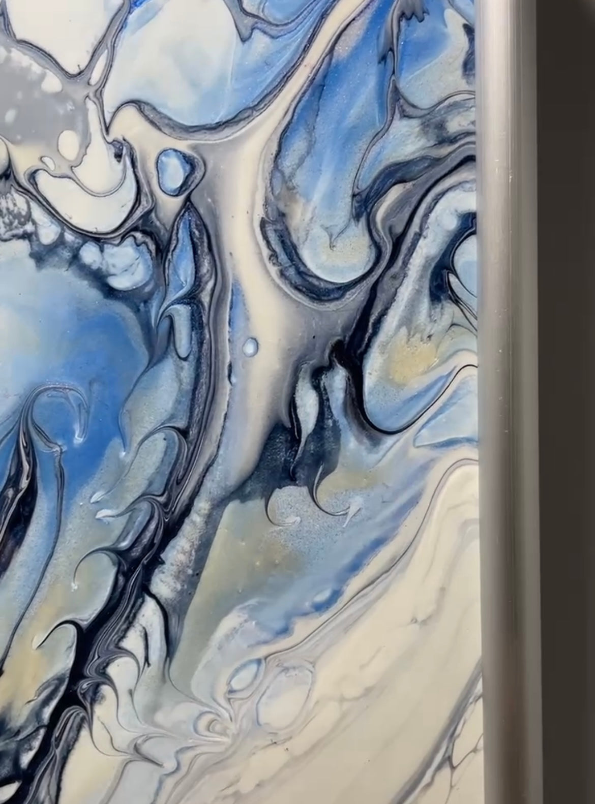 Abstract art with swirling blue, black, and white patterns on a dark background