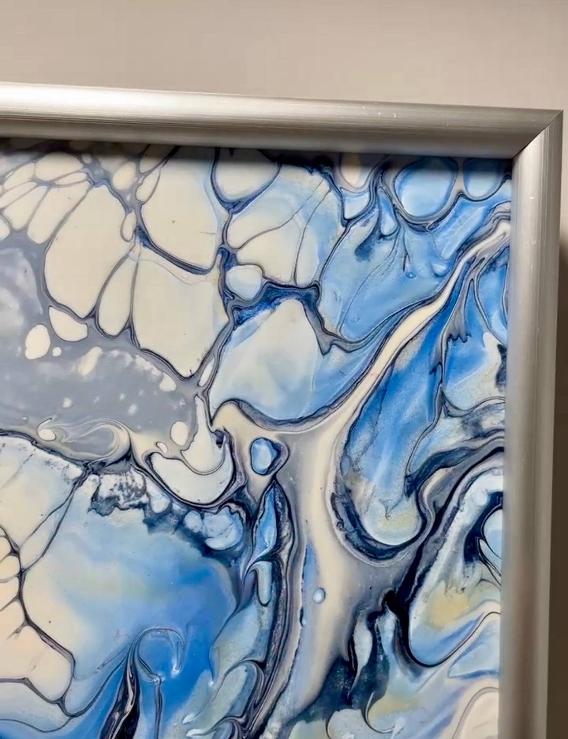 Abstract art piece with blue and white colours in a brushed Aluminium silver frame.