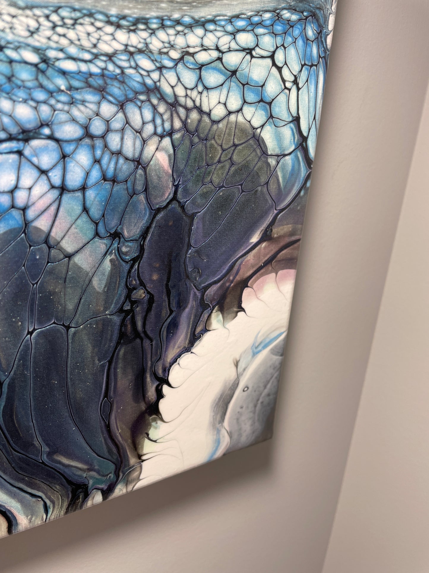 Close-up of a textured wall art piece with blue and gray patterns.